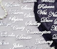 the names of many different people are displayed on a table with pearls and other items