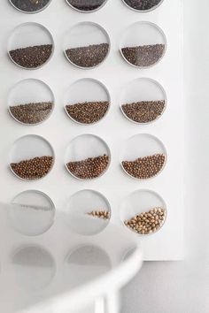 a white table topped with lots of bowls filled with different types of seeds and grains