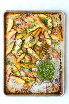 baked potato wedges with pesto and parsley on a baking sheet, ready to be served