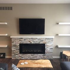 a living room with two couches and a television mounted on the wall above it