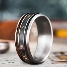 a close up of a wedding ring on top of a piece of paper with other items in the background