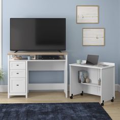 a flat screen tv sitting on top of a white desk