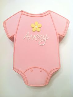 a pink bodysuit with the word avery written on it and a yellow flower in the center