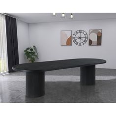 a large black table in the middle of a room with two clocks on the wall