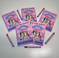 four children's books with pencils on top of them and the cover is pink