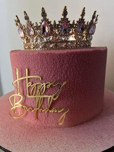 a pink hat with a tiara on top that says happy birthday in cursive writing