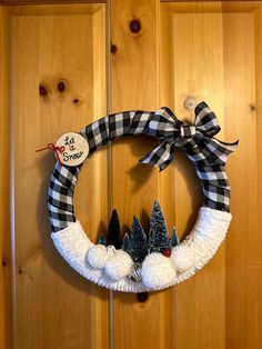 a wreath decorated with pom poms is hanging on the front door to give it a festive touch