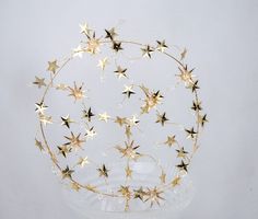 a glass bowl filled with gold stars on top of a table