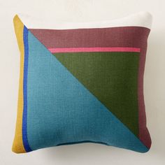 a multicolored pillow sitting on top of a white wall