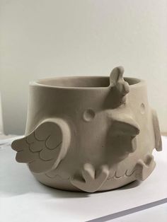 a white ceramic bowl with an animal design on the front and side, sitting on a table