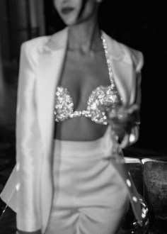 a black and white photo of a woman in a suit with sequins on it