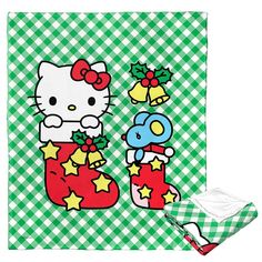 a hello kitty christmas stocking on a green and white checkered table cloth next to an oven mitt