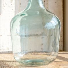 a glass bottle sitting on top of a wooden table