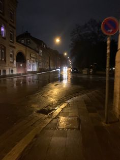 a wet street at night with no cars on it