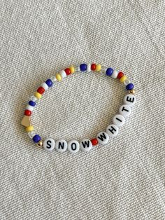 a beaded bracelet with the word snow written in white and multicolored beads