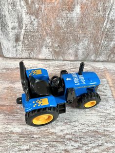 a blue toy tractor sitting on top of a wooden table