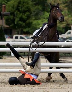 a woman falling off her horse while riding it