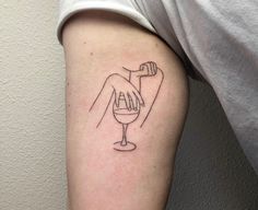 a person with a wine glass tattoo on their arm