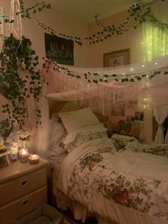 a bedroom decorated in pink and white with greenery hanging from the ceiling