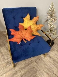 an orange and yellow leaf sitting on top of a blue chair