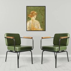 two green chairs sitting next to each other in front of a painting on the wall