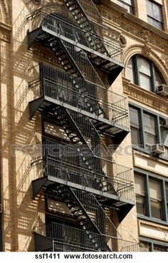 a fire escape on the side of an apartment building with wrought iron railings and balconies