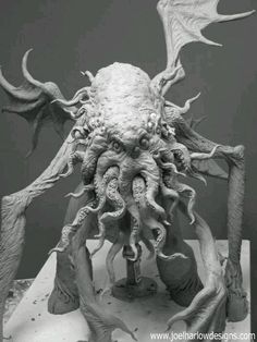 an intricately detailed sculpture is displayed in black and white, with large horns on it's head