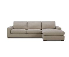 a beige sectional couch sitting on top of a white floor