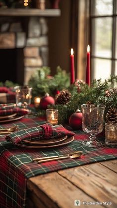 the table is set for christmas dinner with red and green plaid napkins on it