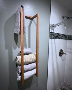 towels are hanging on a towel rack in a bathroom with gray walls and tiled floors