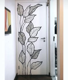 a white door with black leaves painted on it