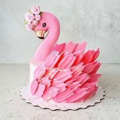 a cake shaped like a pink flamingo with flowers on it's head and body