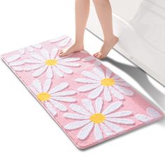 a person standing on a pink rug with white daisies