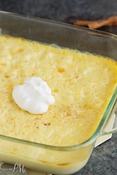 a casserole dish with cream in it sitting on a table next to some cinnamon sticks