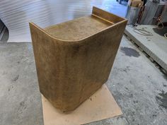 a large wooden chair sitting on top of a piece of cardboard