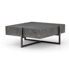 a concrete coffee table sitting on top of a metal stand with one leg raised up