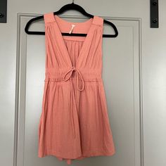 Free People Beach Bound Vneck Tank With Tie Front. Coral Pink/Orange Color. New With Tags In Perfect Condition Never Been Worn. Size Small Orange V-neck Top For Day Out, Beachy V-neck Top For Day Out, Cotton V-neck Beachwear Tops, V-neck Tops For Beach Season, Spring Beachwear V-neck Tops, Summer V-neck Tops For Beach Season, Pink V-neck Top For Vacation, Spring V-neck Beachwear Top, Pink Beachy Tops For Spring