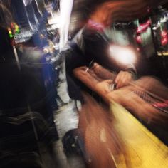 a blurry photo of a person sitting on a bench in the city at night