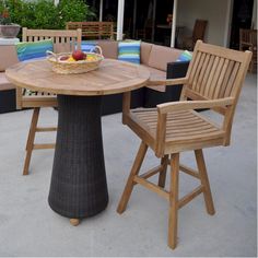 an outdoor table with two chairs and a bowl of fruit on it's end