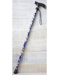 an old style walking stick with blue and white flowers on it, resting against a wall