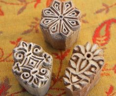 three carved wooden beads sitting on top of a rug