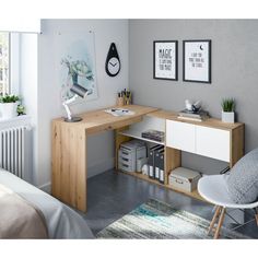 a room with a desk, chair and pictures hanging on the wall in front of it