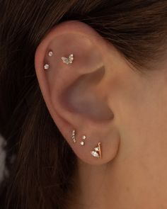 a close up of a person's ear with three different types of piercings