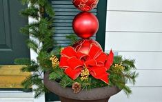 a potted planter with christmas decorations on the top and in front of a house