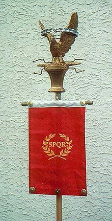 an eagle statue on top of a red banner with the word spqr above it