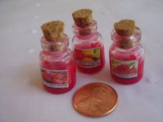 four small jars with cookies in them next to a penny