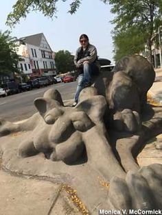 a man sitting on top of an elephant statue