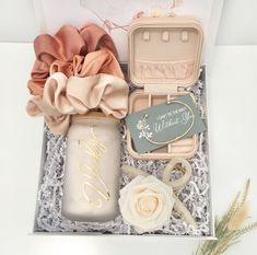 an open box with some flowers and other items in it on a white table top