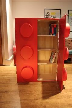 a red book case with wheels on the bottom and shelves in front of it that are made out of plywood