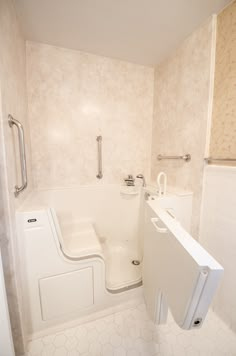 a bathroom with a bathtub, toilet and shower head in the wall next to it